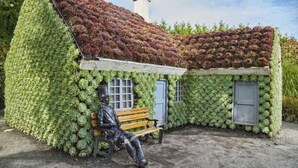A building covered with plants, a bench, and a statue. - Rural apartment near the North Sea, ideal for excursions in the surrounding area (Fjerritslev)