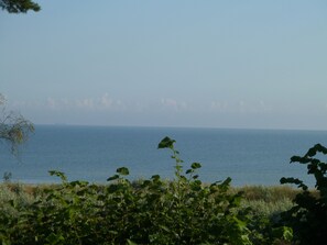 Un paysage côtier avec vue sur la mer et un premier plan composé d’une prairie.