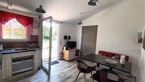 A compact kitchen with a sink, stove, and a dining area with a table and chairs. - HOUSE 4 PERS + SPA + HEATED POOL CALM & REST IN MARAIS POITEVIN VENDEE (Liez)