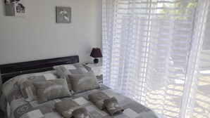 A neatly made bed with a patterned bedspread, pillows, and folded blankets. - HOUSE 4 PERS + SPA + HEATED POOL CALM & REST IN MARAIS POITEVIN VENDEE (Liez)