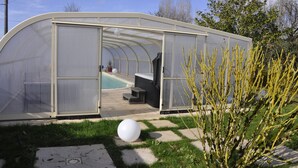 A greenhouse with a curved roof, a pool, and a patio area with seating. - HOUSE 4 PERS + SPA + HEATED POOL CALM & REST IN MARAIS POITEVIN VENDEE (Liez)