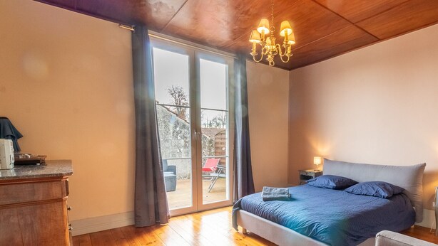 A bedroom with a bed, a nightstand, a dresser, and a sliding glass door leading to an outdoor area. - Large atypical charming house entirely renovated. (Jonzac)