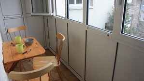 A small kitchen with a wooden table, two chairs, a bowl, and two mugs. - Central apartment near train station  (Saint-Malo)