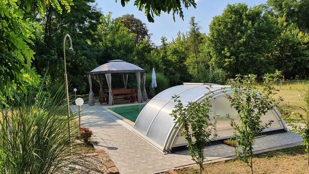 Une serre dotée d’un toit transparent, un belvédère et une petite piscine.