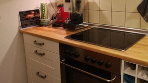A compact kitchen with a built-in oven, a stovetop, and a coffee machine. - Quiet vacation oasis with a beautiful view over Bad Lauterberg (Bad Lauterberg)