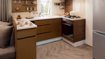 A modern kitchen with wooden cabinets, a built-in oven, and a refrigerator.