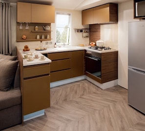 Una cocina moderna con armarios de madera, horno empotrado y refrigerador.