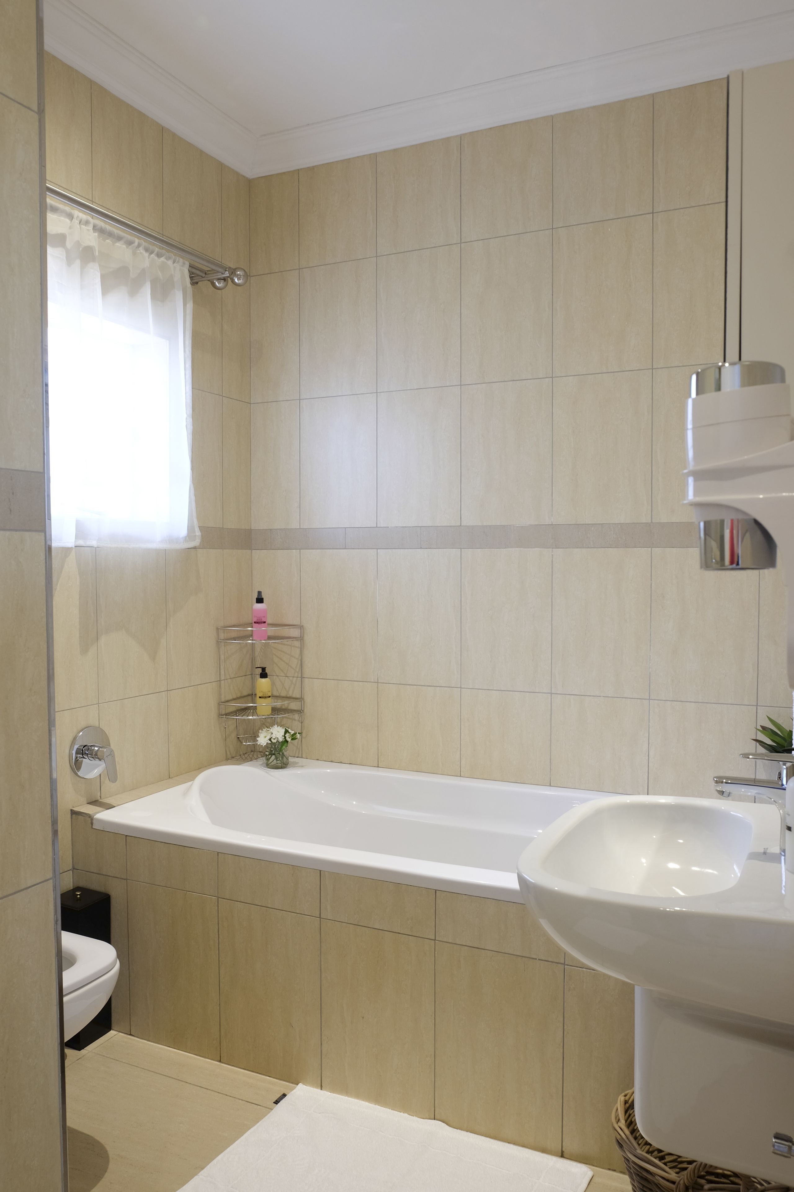 A modern bathroom with a bathtub, a sink, and a toilet.