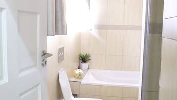 A bathroom with a toilet, sink, and bathtub.