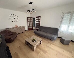 A modern living room with a sofa, coffee table, and a clock on the wall. - IN VILLA, APARTMENT ALL COMFORT WITH PARKING  (Arles)