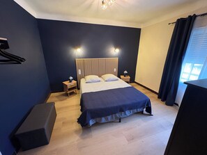 A bedroom with a bed, bedside tables, a nightstand, a dresser, a window with curtains, and a wall-mounted light fixture. - IN VILLA, APARTMENT ALL COMFORT WITH PARKING  (Arles)
