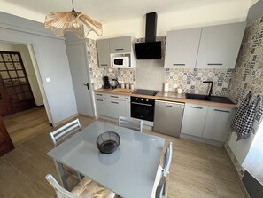 A modern kitchen with a dining table, chairs, a microwave, a stove, and a sink. - IN VILLA, APARTMENT ALL COMFORT WITH PARKING  (Arles)