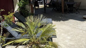 A patio with outdoor furniture, a pergola, and a palm tree. - IN VILLA, APARTMENT ALL COMFORT WITH PARKING  (Arles)