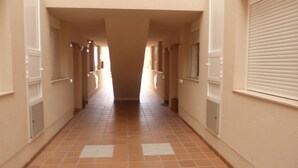 A corridor with tiled flooring and white walls.