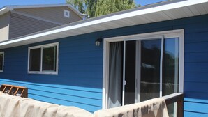 A blue house with a covered porch and a sliding glass door. - Near everything. Surrounded by parks, and trails. Sleeps 6. Basecamp for Montana (Bozeman)