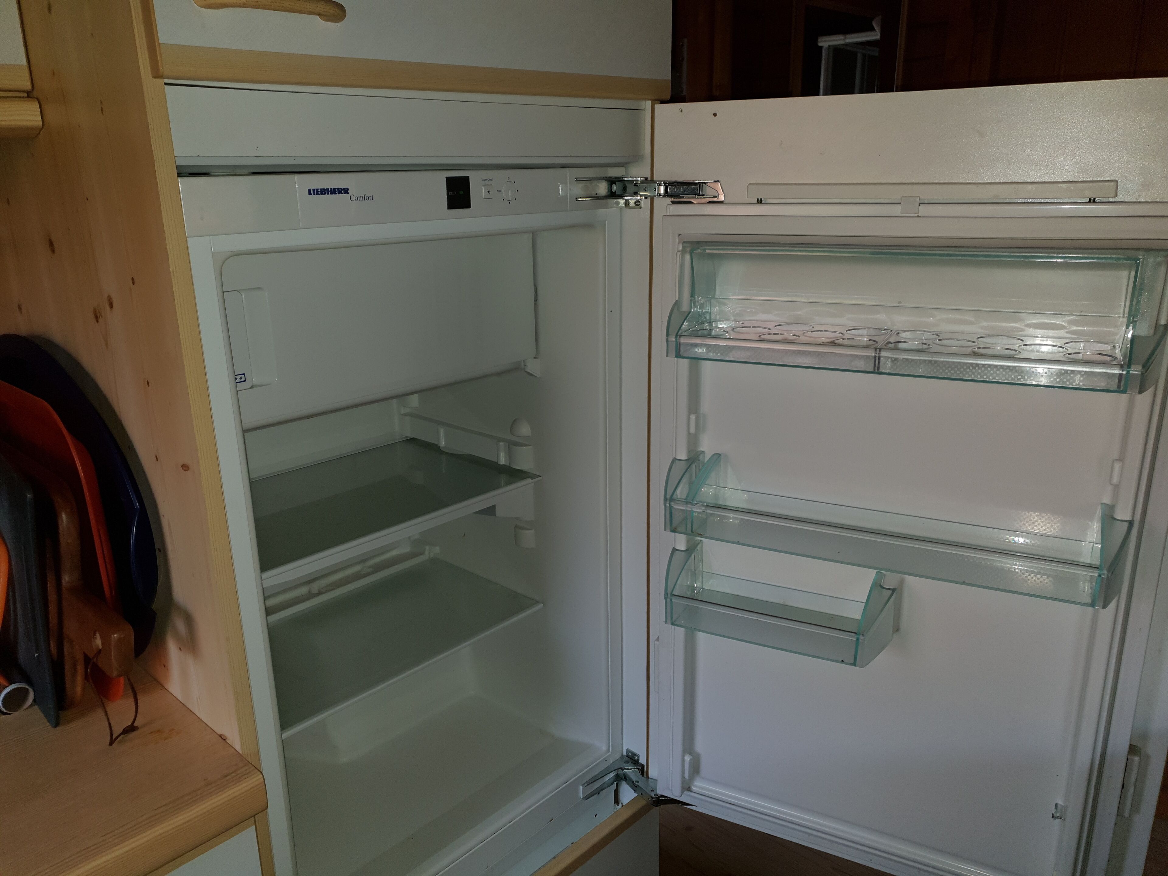 An open refrigerator with multiple shelves and a control panel on top.