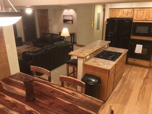 Enjoy cooking in the fully equipped kitchen with a central island, stovetop, refrigerator, and oven.
