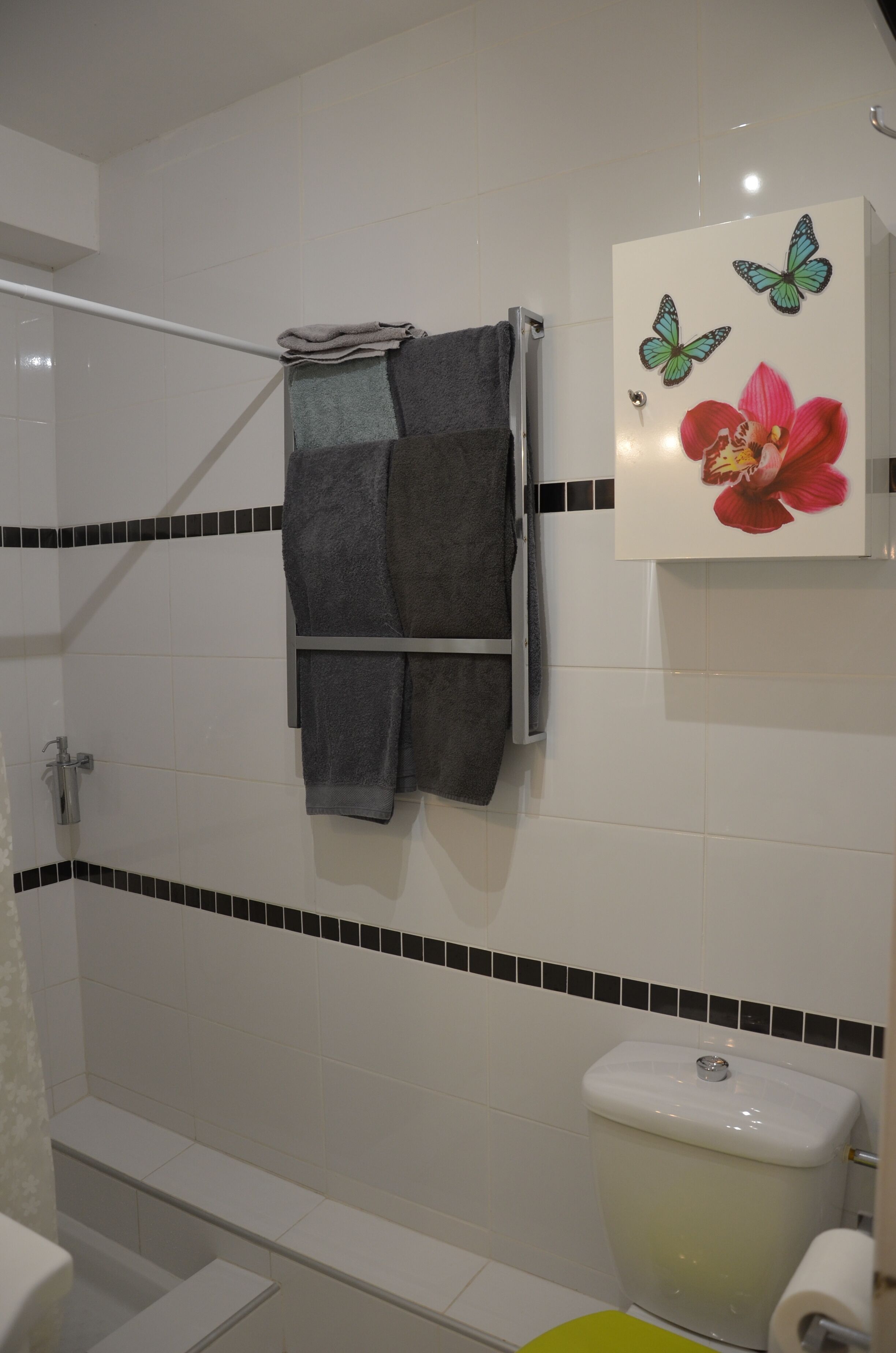 Kylpyhuone, jossa on wc, pesuallas ja pyyheteline, jossa on kaksi pyyhettä.