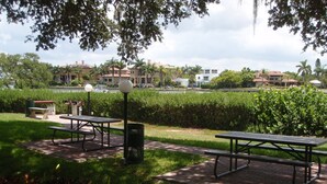A park with picnic tables, benches, and a trash can. - Siesta Key 2 Bedroom Condo  (Siesta Key)