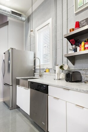 Enjoy cooking in this well-equipped kitchen with a refrigerator, dishwasher, and ample countertop space.