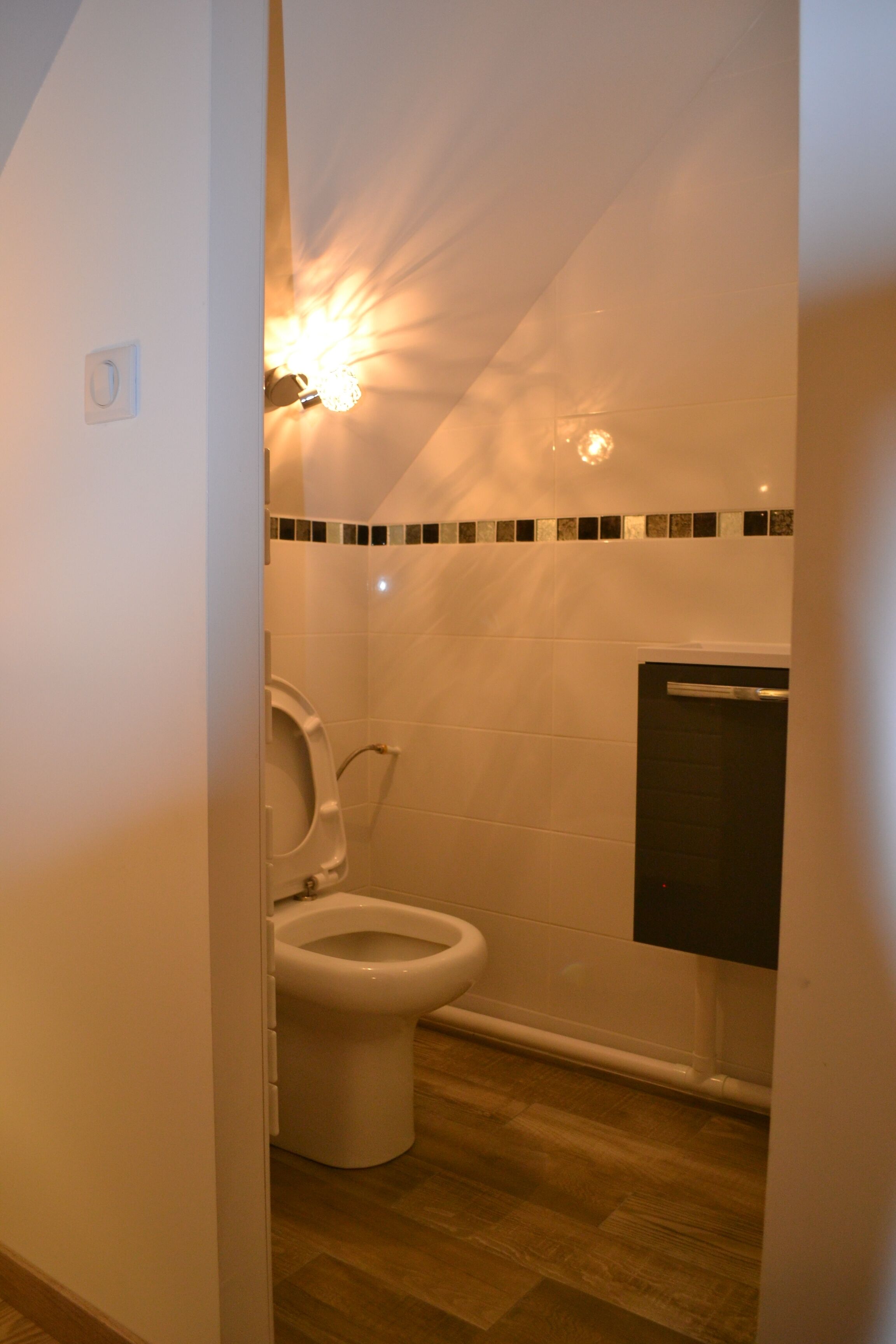 Een badkamer met toilet, wastafel en spiegel.