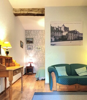 En hyggelig stue med et træbord, en grøn sofa og en lampe.