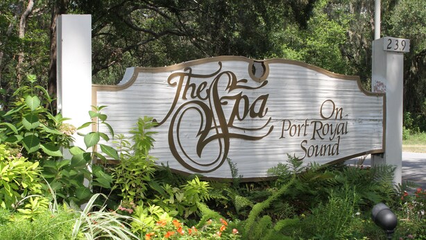 A sign with the text "The Spa On Port Royal Sound" surrounded by greenery and flowers. - Cozy, Private, Gated,  Hilton Head Location with Great Views. Steps to the beach (Hilton Head Island)