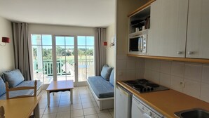 Una cocina compacta con comedor, horno empotrado y lavavajillas.