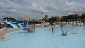 Una piscina con toboganes de agua y una torre de salvavidas.