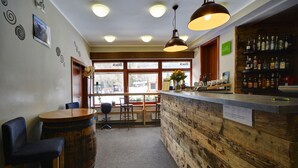 Zona de bar con mostrador de madera, taburetes y un ventanal con vistas.