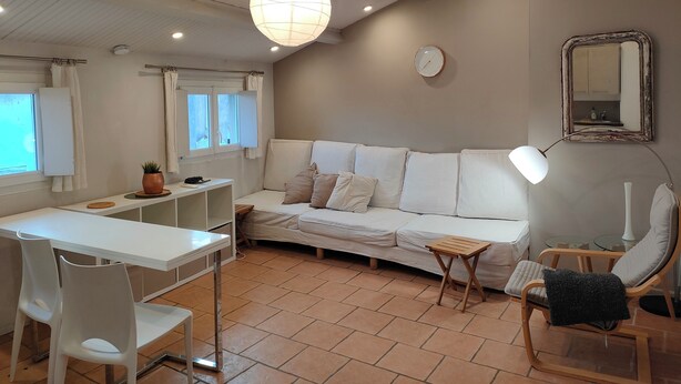 A modern living room with a white sofa, a dining table with chairs, a small side table, and a ceiling light fixture. - conditioning housing and equipped view roofs central, separate bedroom (Aix-en-Provence)