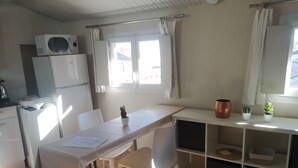 A compact kitchen with a dining area, white cabinets, a microwave, and a refrigerator. - conditioning housing and equipped view roofs central, separate bedroom (Aix-en-Provence)