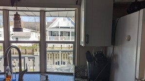 Una cocina con un ventanal amplio, un lavamanos y un refrigerador.