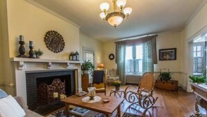 Una sala de estar acogedora con chimenea, muebles de madera y una araña.