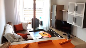 Un soggiorno moderno con un divano, un tavolo da pranzo e una televisione.