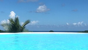 Ein klarer, blauer Himmel, ein weißer, sandiger Strand und ein ruhiges Meer.