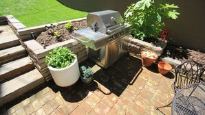 A patio with a stainless steel grill, potted plants, and a metal chair. - In the Heart of Historic Downtown Paris KY (Paris)