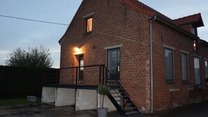 A brick building with a staircase and a small potted plant.