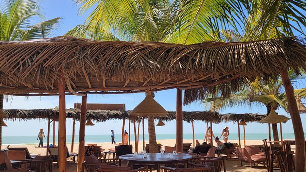 A beachside restaurant with thatched umbrellas, wooden furniture, and a view of the ocean. - DOLMEN DE M'BOUR - Your next dream vacation, 5 min from the ocean (M'bour)