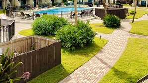 A resort with a swimming pool surrounded by palm trees and a brick pathway. - Beautiful gated community,  (Panama City)