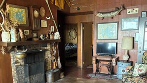Un salon confortable avec une cheminée, un téléviseur et un canapé.
