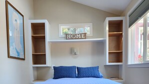 A bedroom with a bed, a bench, and built-in shelving units. - ~AMITABHA~ Wine Country Cottage! Perfectly Located in Santa Rosa (Santa Rosa)