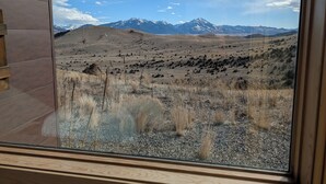 A view from a window of a building with a mountainous landscape in the background.