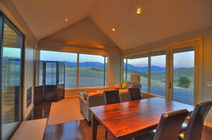 Enjoy meals with a mountain view from the large dining table surrounded by chairs.