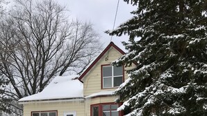 A two-story building with a stone foundation and a red roof.