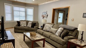 A living room with two couches, a coffee table, and a TV stand.