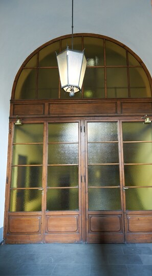 A large wooden door with glass panels and a hanging light fixture. - Breathtaking view on Ponte Vecchio! (Firenze)