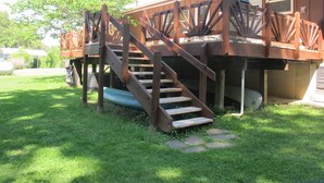 A wooden deck with a staircase leading to a house.