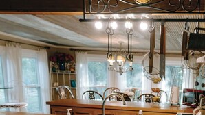 A rustic kitchen with a wooden island, a chandelier, and a large window.