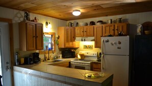 A kitchen with wooden cabinets, a white refrigerator, and a stove.